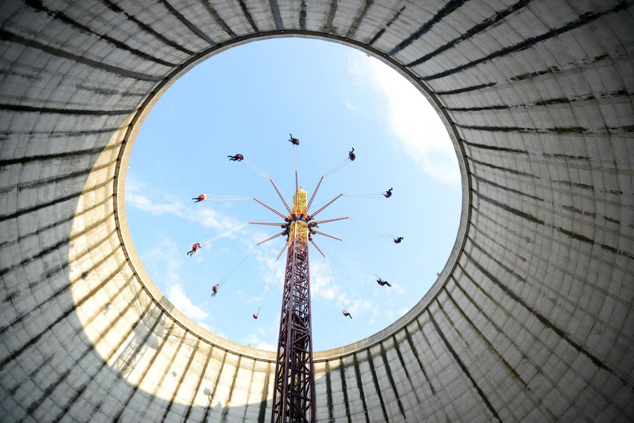 Bild: sich drehendes Kettenkarussel in einem stillgelegten Kühlturm