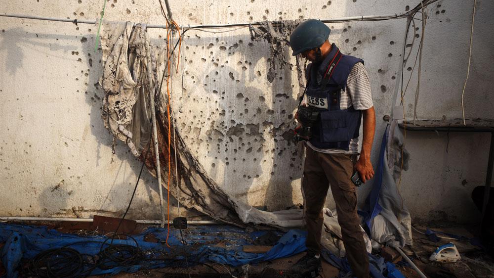 Bild: Ein Journalist betrachtet Einschusslöcher in einer Wand in Gaza