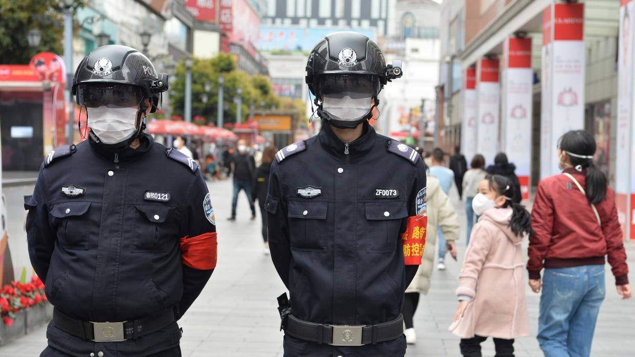 Bild: Zwei Polizisten in China messen die Körpertemperatur von Passanten mittels spezieller Helme