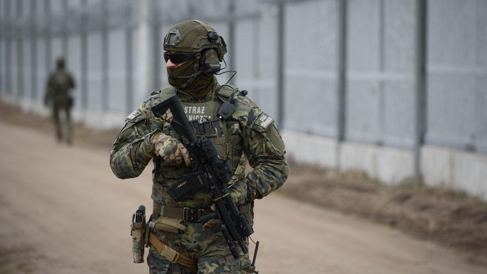 Bild: Amerikanischer Soldat in voller Montur vor einem Stacheldrahtzaun