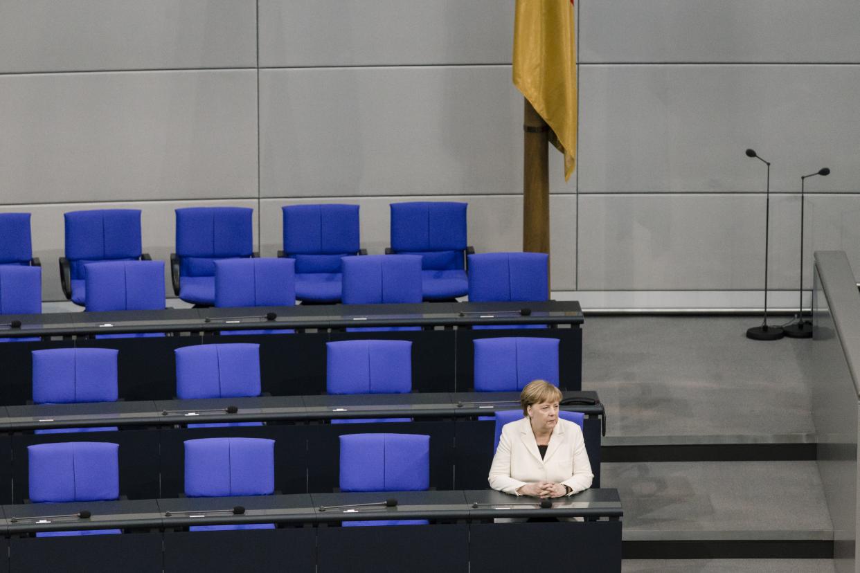 Bild: Angela Merkel allein in einer leeren Stuhlreihe im Bundestag