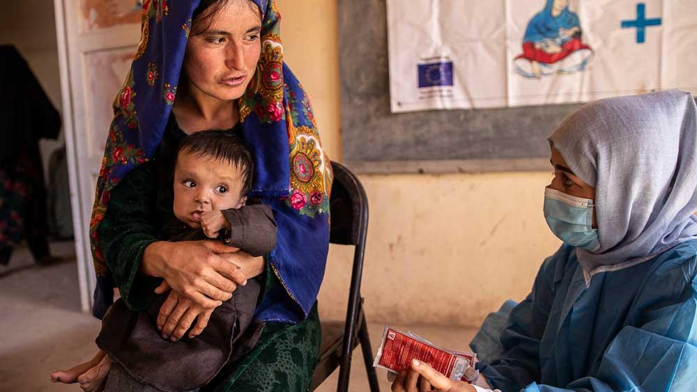 Bild: Eine Mitarbeiterin einer NGO berät eine junge afghanische Mutter