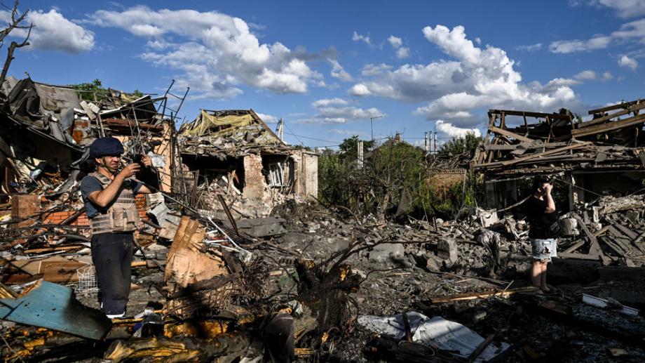 Bild: Ein Mann inmitten bombardierter und zerstörter Häuser in der Ukraine.