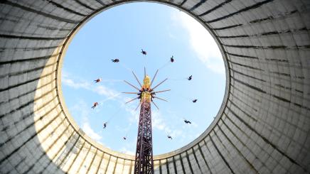 Bild: sich drehendes Kettenkarussel in einem stillgelegten Kühlturm