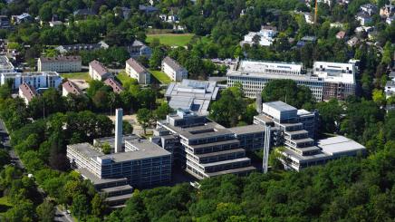 Bild: Luftaufnahme des Gebäudekomplexes des Bundeskriminalamts, umgeben von Bäumen und Wohngebäuden.