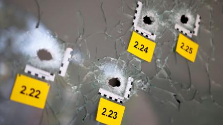 Bild: Vermessene Einschusslöcher in einer Glasscheibe.