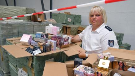 Bild: Zollbeamtin mit Kisten voller Beauty-Produkten.