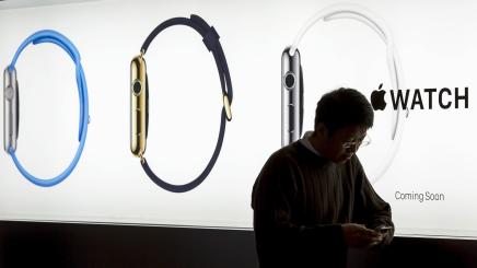 Bild: Mann vor einer beleuchtetetn Apple Watch Werbung